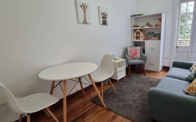 Box 1: sofá, mesa redonda con sillas y estante con material de juego infantil